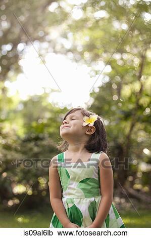 Young girl in garden, wearing flower in her hair View Large Photo Image Stock Image - Young girl in garden, wearing flower in her hair. Fotosearch