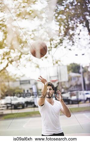 Young male basketball player throwing ball to basketball hoop View Large Photo Image Stock Image - Young male basketball player throwing ball to basketball hoop. Fotosearch