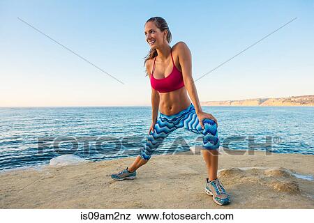 Young woman doing stretches on beach View Large Photo Image Stock Photo - Young woman doing stretches on beach. Fotosearch