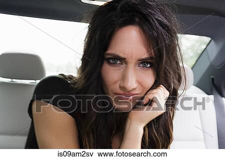 Young woman in car, frowning View Large Photo Image Stock Photo - Young woman in car, frowning. Fotosearch