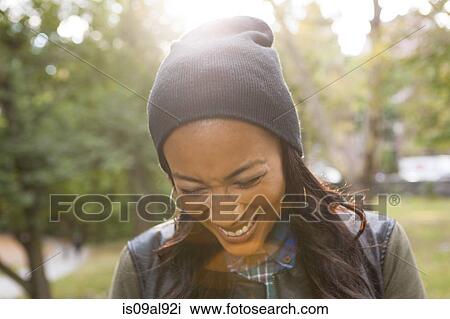 Young woman laughing in park View Large Photo Image Stock Image - Young woman laughing in park. Fotosearch