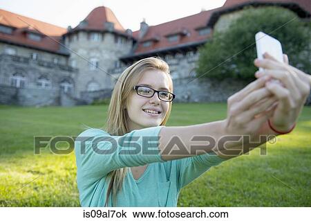 Young woman photographing herself with cameraphone View Large Photo Image Stock Image - Young woman photographing herself with cameraphone. Fotosearch