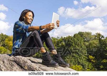 Young woman using digital tablet View Large Photo Image Stock Photo - Young woman using digital tablet. Fotosearch