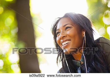 Young woman with wide smile in park View Large Photo Image Stock Image - Young woman with wide smile in park. Fotosearch