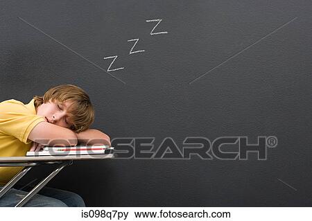 Stock Photo - A boy sleeping on his desk. Fotosearch