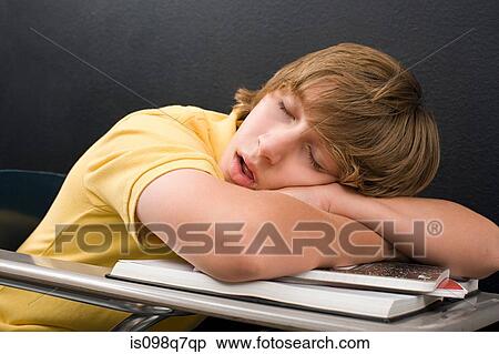 Stock Photography - A boy sleeping on his desk. Fotosearch