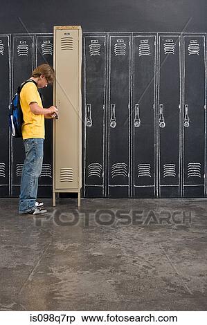 Stock Photography - A boy unlocking his locker. Fotosearch