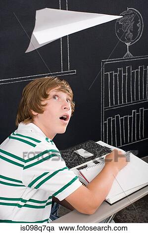 Stock Image - A boy with a paper airplane over his head. Fotosearch