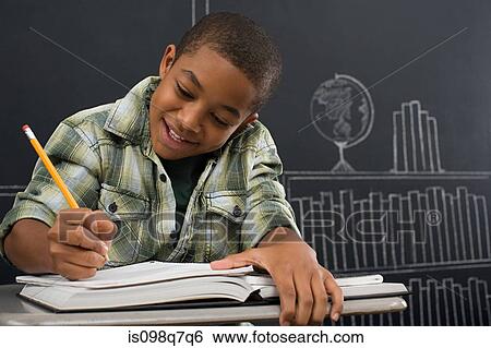 A boy writing in a notebook View Large Photo Image Stock Photograph - A boy writing in a notebook. Fotosearch