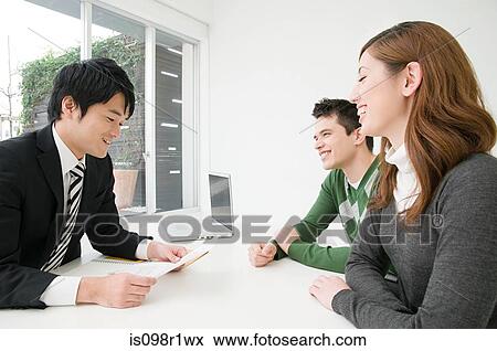 A businessman in a meeting with clients View Large Photo Image Stock Photo - A businessman in a meeting with clients. Fotosearch