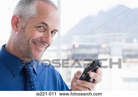 Stock Image - A businessman using a cell phone. Fotosearch