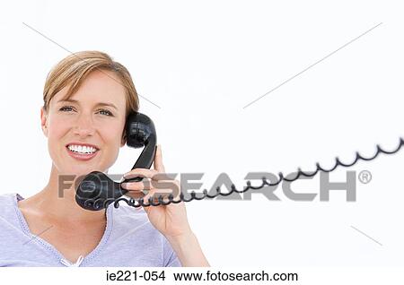 A businesswoman holding a telephone View Large Photo Image Picture - A businesswoman holding a telephone. Fotosearch