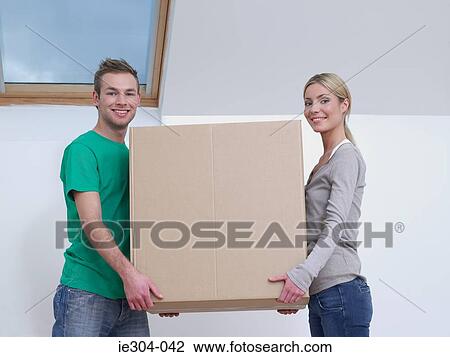 Stock Image - A couple carrying a cardboard box. Fotosearch