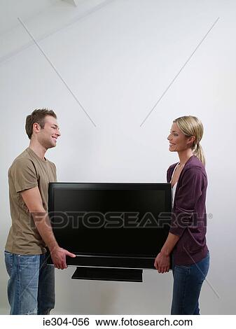 A couple carrying a tv View Large Photo Image Stock Photograph - A couple carrying a tv. Fotosearch