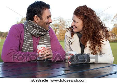 A couple face to face sitting at a park table View Large Photo Image Stock Image - A couple face to face sitting at a park table. Fotosearch