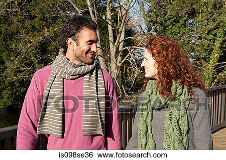 A couple hold hands whilst crossing a bridge View Large Photo Image Stock Photograph - A couple hold hands whilst crossing a bridge. Fotosearch