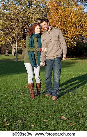 Stock Photo - A couple holding hands in dulwich park. Fotosearch