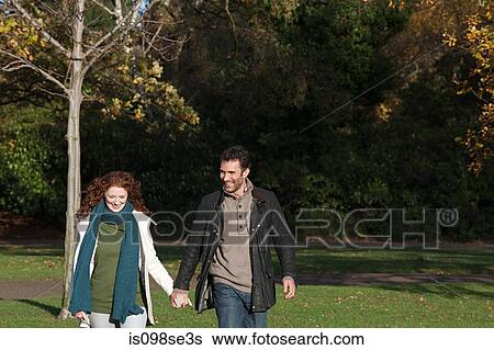 Stock Photograph - A couple holding hands in dulwich park. Fotosearch