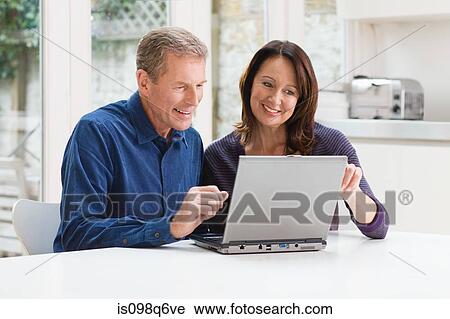 A couple using a laptop View Large Photo Image Stock Image - A couple using a laptop. Fotosearch