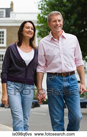 A couple walking down the street View Large Photo Image Stock Photograph - A couple walking down the street. Fotosearch