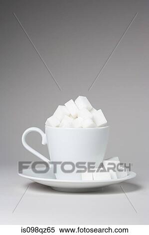 Stock Photography - A cup full of sugar lumps. Fotosearch