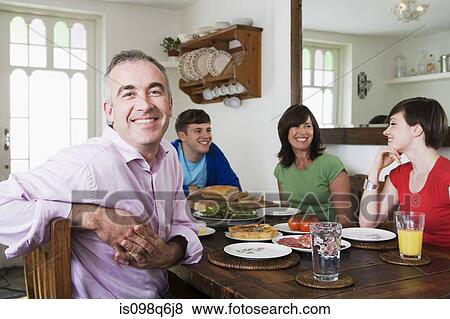 Stock Photo - A family sat at a dining table. Fotosearch