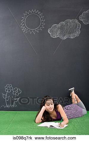 Stock Image - A girl writing in notebook. Fotosearch