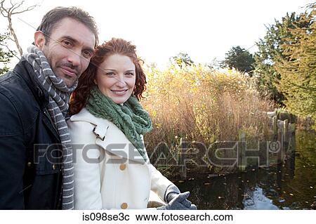 Stock Image - A happy couple beside the water in dulwich park. Fotosearch