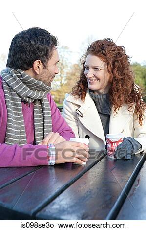 A happy couple sitting at a park table View Large Photo Image Picture - A happy couple sitting at a park table. Fotosearch