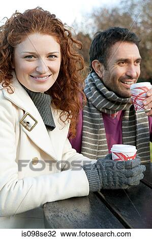 A happy couple sitting at a park table View Large Photo Image Stock Image - A happy couple sitting at a park table. Fotosearch