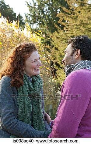 A happy couple stand face to face in dulwich park View Large Photo Image Stock Image - A happy couple stand face to face in dulwich park. Fotosearch
