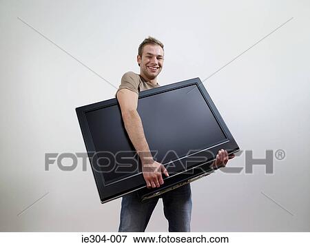 A man holding a tv View Large Photo Image Stock Photo - A man holding a tv. Fotosearch