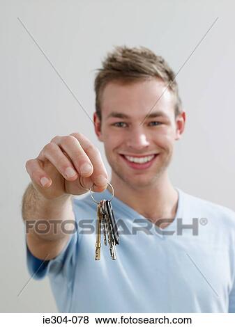Stock Photo - A man holding keys. Fotosearch