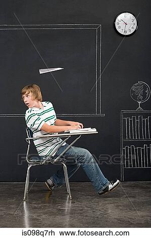 Stock Image - A paper airplane over a boys head. Fotosearch