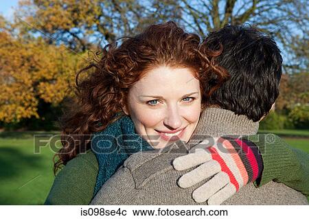 Stock Image - A smiling woman looking over the shoulder of her partner. Fotosearch