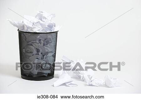 A wastepaper basket with crumpled up paper in it View Large Photo Image Picture - A wastepaper basket with crumpled up paper in it. Fotosearch