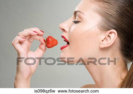 A woman eating a strawberry View Large Photo Image Stock Photo - A woman eating a strawberry. Fotosearch