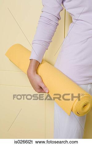 A woman holding a yoga mat View Large Photo Image Stock Photograph - A woman holding a yoga mat. Fotosearch
