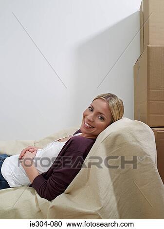 Stock Image - A woman reclining on a sofa. Fotosearch