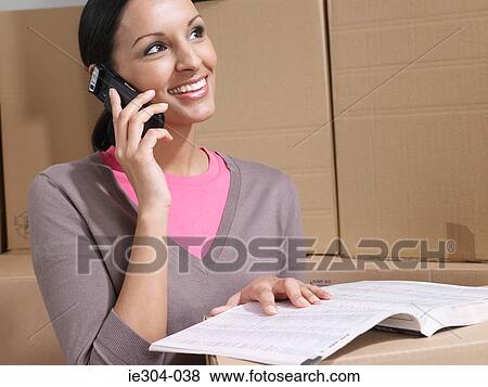 Stock Photo - A woman using a cell phone. Fotosearch