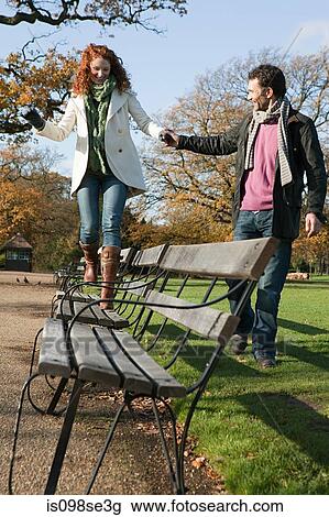 A woman walking across a park bench View Large Photo Image Stock Image - A woman walking across a park bench. Fotosearch