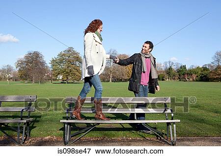 A woman walking across a park bench View Large Photo Image Stock Photo - A woman walking across a park bench. Fotosearch