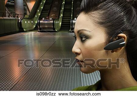 A woman wearing a bluetooth headset View Large Photo Image Stock Photo - A woman wearing a bluetooth headset. Fotosearch