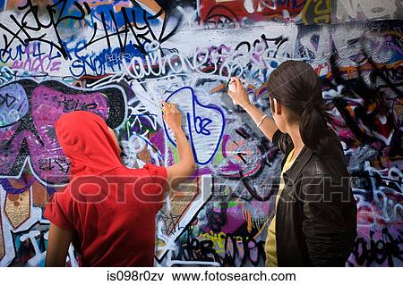 A young man and woman spraying graffiti View Large Photo Image Stock Photo - A young man and woman spraying graffiti. Fotosearch