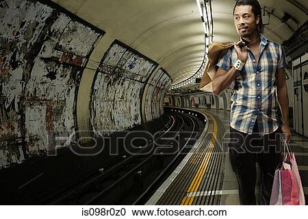 Stock Image - A young man carrying shopping bags. Fotosearch