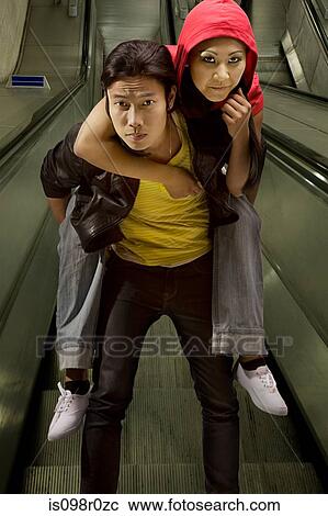 A young man giving his girlfriend a piggyback View Large Photo Image Stock Image - A young man giving his girlfriend a piggyback. Fotosearch