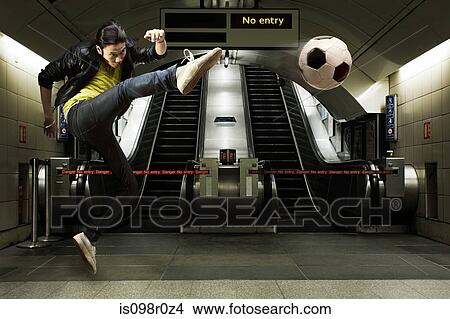 A young man kicking a football View Large Photo Image Picture - A young man kicking a football. Fotosearch