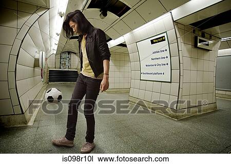 Stock Image - A young man playing keepy uppy. Fotosearch