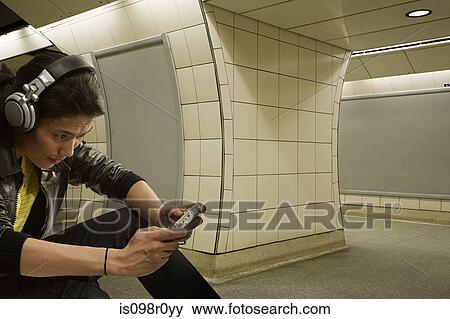 A young man playing on a handheld computer View Large Photo Image Stock Photo - A young man playing on a handheld computer. Fotosearch