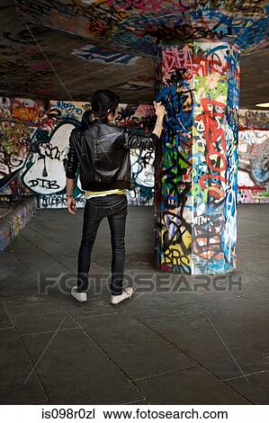 A young man spraying graffiti View Large Photo Image Stock Image - A young man spraying graffiti. Fotosearch